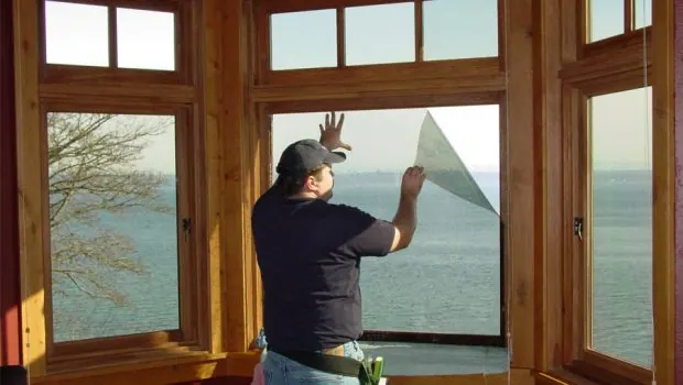 Professional installer applying window film to residential glass in Sydney